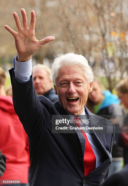 Former U.S. President Bill Clinton waves as he leaves the 20th International AIDS Conference at The Melbourne Convention and Exhibition Centre on...