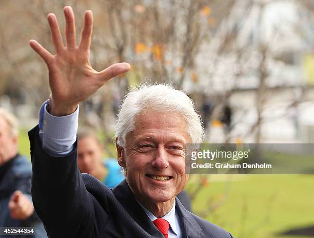 Former U.S. President Bill Clinton waves as he leaves the 20th International AIDS Conference at The Melbourne Convention and Exhibition Centre on...