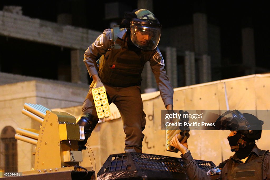 Two Israeli soldiers exchange empty volleys of tear gas for...