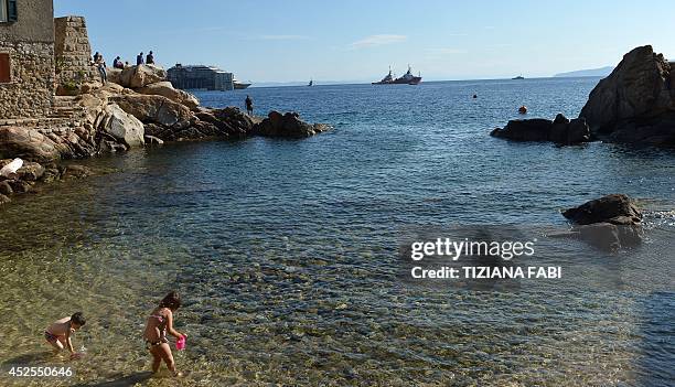 People watch the wreck of the Costa Concordia cruise ship as it is towed away in front of the harbour of Isola del Giglio, after it was refloated...