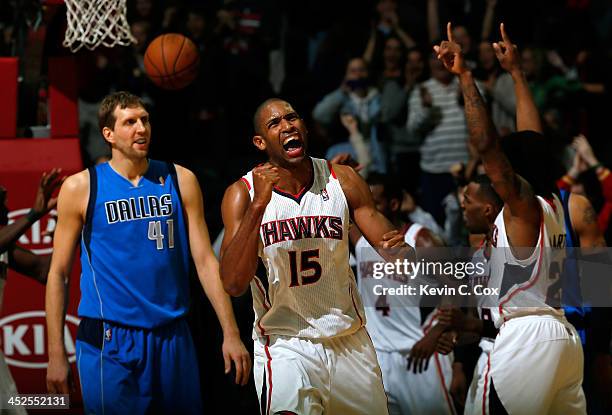 Al Horford of the Atlanta Hawks celebrates their 88-87 win over Dirk Nowitzki of the Dallas Mavericks at Philips Arena on November 29, 2013 in...