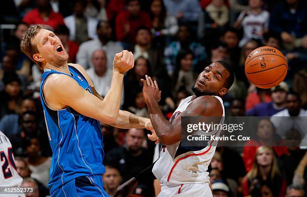 Paul Millsap of the Atlanta Hawks fouls Dirk Nowitzki of the Dallas Mavericks at Philips Arena on November 29, 2013 in Atlanta, Georgia. NOTE TO...