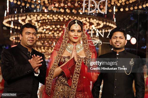 Actresses Bipasha Basu with owners of Shree Raj Mahal Jewellers Praveen Goel and Ashok Goel at the India Couture Week 2014 finale held on July 20,...