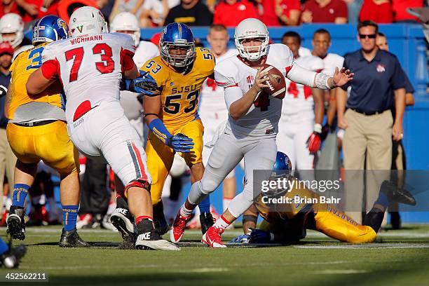 Quarterback Derek Carr of the Fresno State Bulldogs wiggles free of a tackle by linebacker Keith Smith of the San Jose State Spartans on a back and...