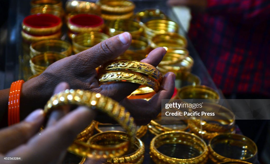 An Indian Muslim lady looks for  gold bangles in a shop in...