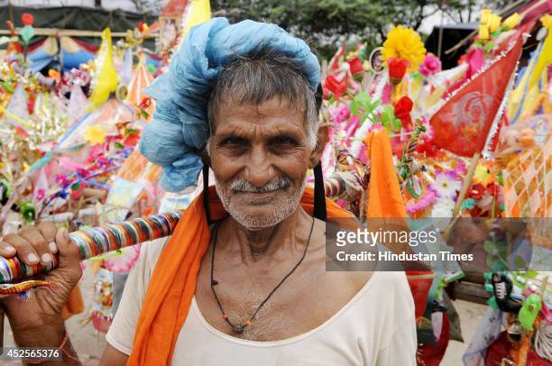Hindu pilgrim known as Kanwaria carrying holy water collected from river Ganges on July 23, 2014 in Noida, India. Kanwar Yatra is annual pilgrimage...
