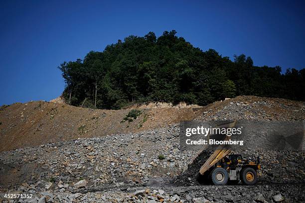 Heavy machinery unloads displaced rock below a new segment of U.S. Highway 460, part of the Appalachian Development Highway System, under...