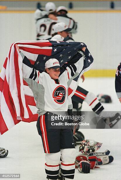 Karyn Bye celebrates the U.S. Women's hockey team victory wrapped in an American flag. The U.S. Beat Canada to take the Olympic gold 3-1.