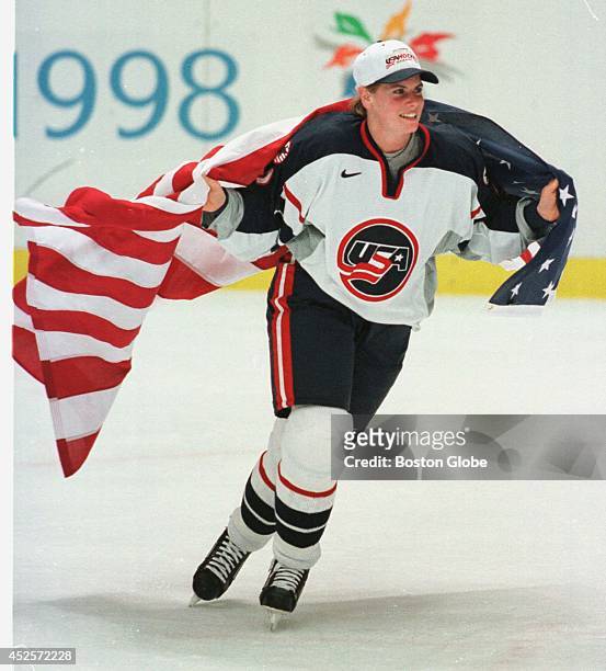 Hockey player Tara Mounsey skates around the rink wearing an American flag during post game celebration after the U.S. Beat Canada to take the...