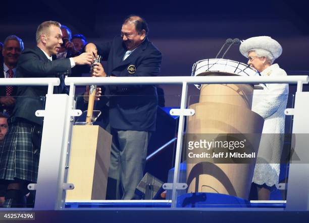 Sir Chris Hoy assists Prince Imran the CGF President attempts to retrieve the message from the baton as he presents it to Queen Elizabeth II, Patron...
