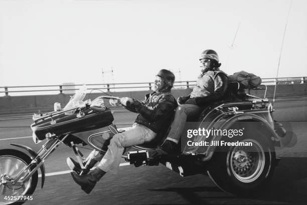 Two men travel on a three wheeled motorcycle, USA, circa 1980.