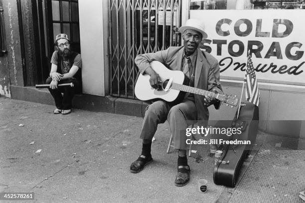 An elderly man plays the guitar on the street in Greenwich Village, New York City, 1970.