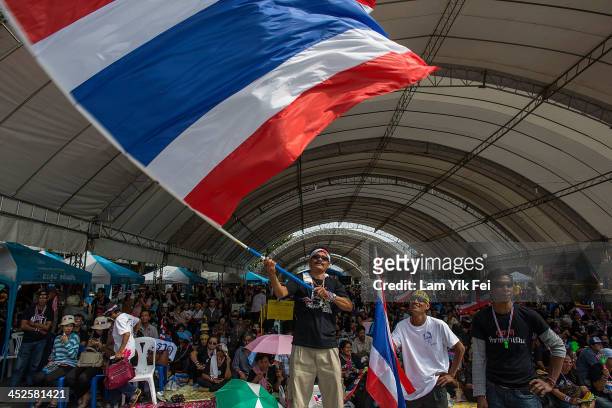 An Anti-government protester waves national flag during a rally at Democracy Monument on November 30, 2013 in Bangkok, Thailand. Anti-government...