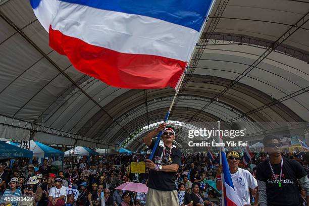 An Anti-government protester waves national flag during a rally at Democracy Monument on November 30, 2013 in Bangkok, Thailand. Anti-government...