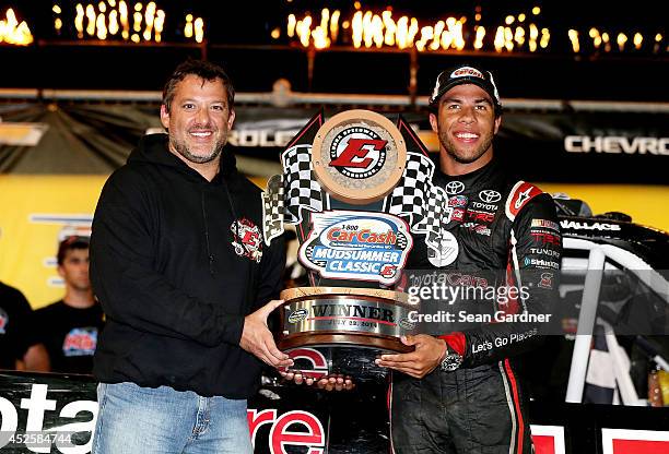 Toney Stewart presents Darrell Wallace Jr. , driver of the ToyotaCare Toyota, with a trophy after winning the Camping World Truck 2nd Annual 1-800...
