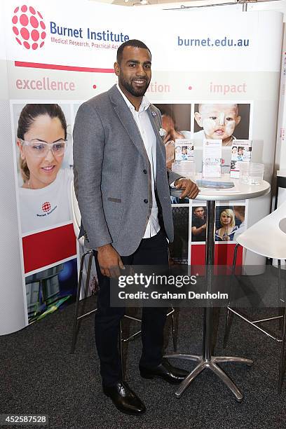 Collingwood AFL player Hertier Lumumba poses at the Burnet Institute stand at the 2014 International Aids Conference on July 24, 2014 in Melbourne,...