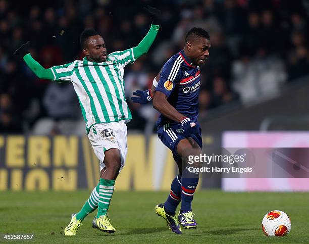 Henri Bedimo of Olympique Lyonnais is challenged by Cedric of Real Betis during the UEFA Europa League Group I match between Olympique Lyonnais and...