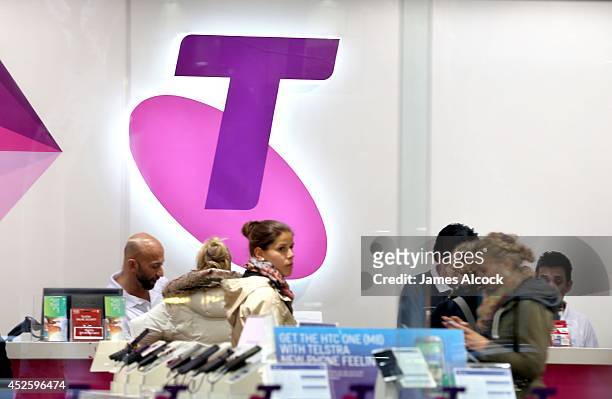 Shoppers in a Telstra retail store in Sydney's CBD browse products on July 24, 2014 in Sydney, Australia. Telstra's Global Services Devision will be...