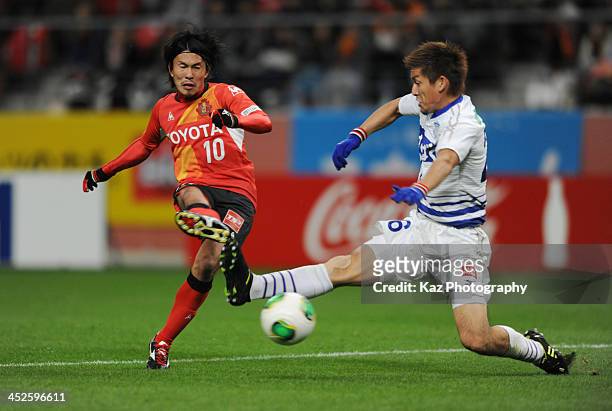 Yoshizumi Ogawa of Nagoya Grampus shoots the ball under the challenge from Sho Sasaki of Ventforet Kofu during the J.League match between Nagoya...