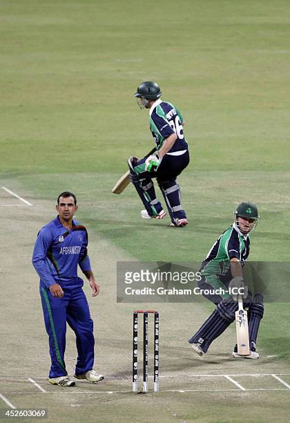 Paul Stirling and William Porterfield of Ireland running between the wickets while Samiullah Shenwari of Afghanistan bowls during the Ireland v...