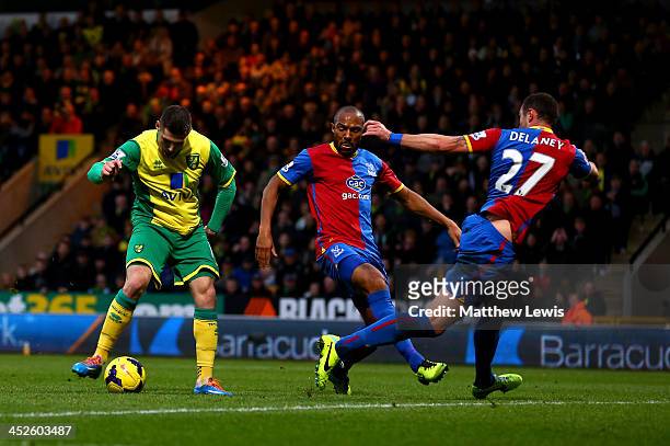 Gary Hooper of Norwich shoots past Danny Gabbidon and Damien Delaney of Palace to score the opening goal during the Barclays Premier league match...