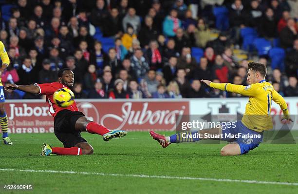 Aaron Ramsey shoots past Cardiff's Gary Medel to score the 3rd Arsenal goal during the match at Cardiff City Stadium on November 30, 2013 in Cardiff,...