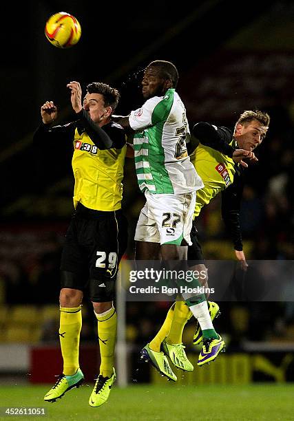Ishmael Miller of Yeovil battles for an aerial ball with George Thorne and Joel Ekstrand of Watford during the Sky Bet Championship match between...