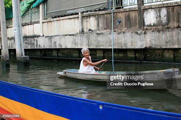 On the khlong of Bangkok, a old woman row a piragua. Anziana donna conduce una piroga nei canali di Bangkok