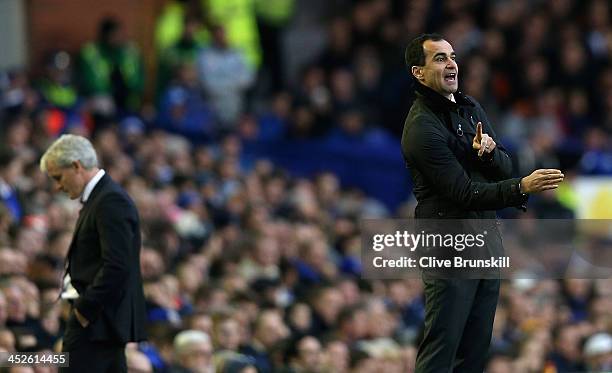 Everton manager Roberto Martinez gives instructions to his team as Stoke City manager Mark Hughes shows his dejection during the Barclays Premier...