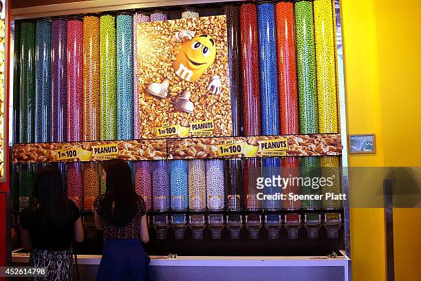 People visit the M&M store in Times Square on July 24, 2014 in New York City. With the increase in cocoa prices, Mars Chocolate North America, the...