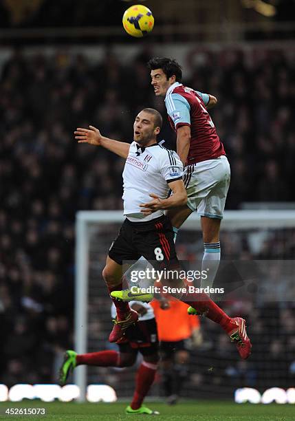 James Tomkins of West Ham United wins a header from Pajtim Kasami of Fulham during the Barclays Premier League match between West Ham United and...