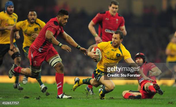 Wallabies fly half Quade Cooper evades the tackle of Leigh Halfpenny of Wales during the International match between Wales and Australia Wallabies at...