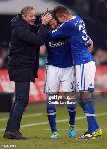 Jermaine Jones of Schalke celebrates with head coach Jens Keller and team mate Roman Neustaedter after scoring his teams third goal during the...