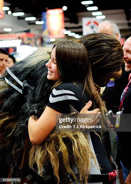 Christopher Petrone, of San Diego, CA, towering over attendees in his handmade, to-scale Chewbacca costume, bends down to hug a fan during the 45th...