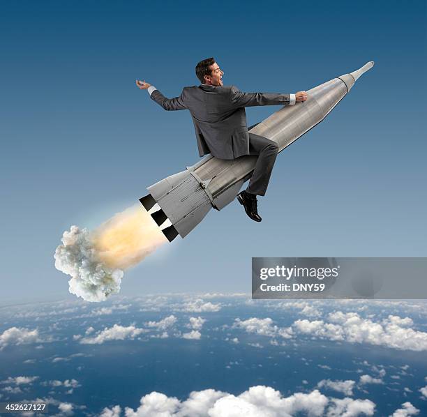 excited businessman riding on a rocket - rocket ride stock pictures, royalty-free photos & images