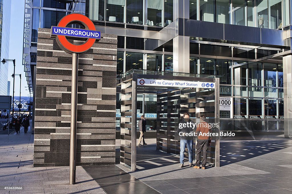 Employees stand by the Canary Wharf Tube station in Canary...