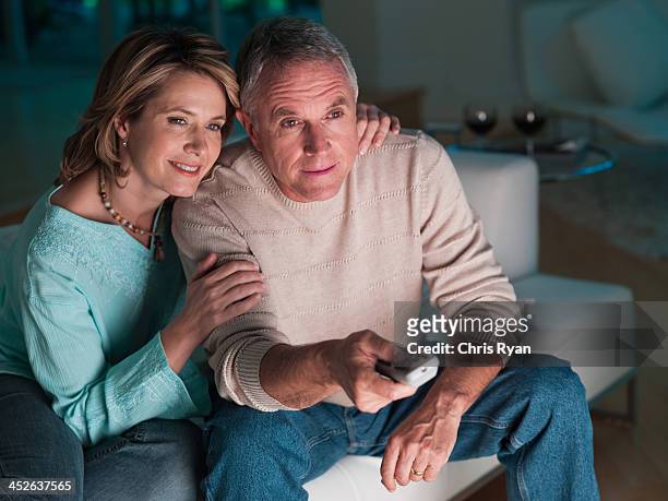 couple in living room watching television - watching tv couple night stock pictures, royalty-free photos & images
