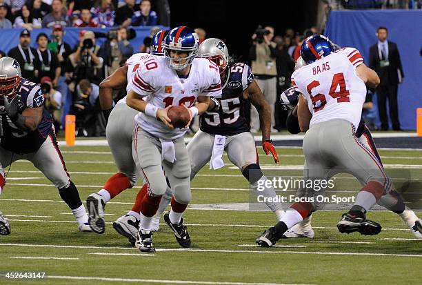 Quarterback Eli Manning of the New York Giants turns to hand the ball off against the New England Patriots during Super Bowl XLVI February 5, 2012 at...