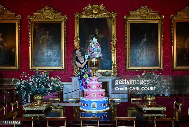 Member of staff poses for photographers with a replica of the cake chosen to celebrate the christening of Queen Victorias youngest son, Prince...