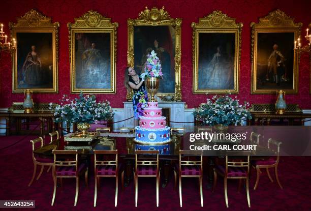 Member of staff poses for photographers with a replica of the cake chosen to celebrate the christening of Queen Victorias youngest son, Prince...