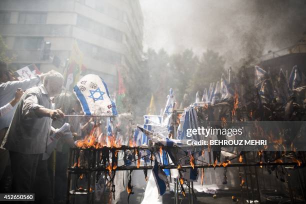 Iranian protestors burn Israeli flags during a demonstration in Tehran on July 25, 2014 to mark the Quds Day. Iranians rallied nationwide in a show...