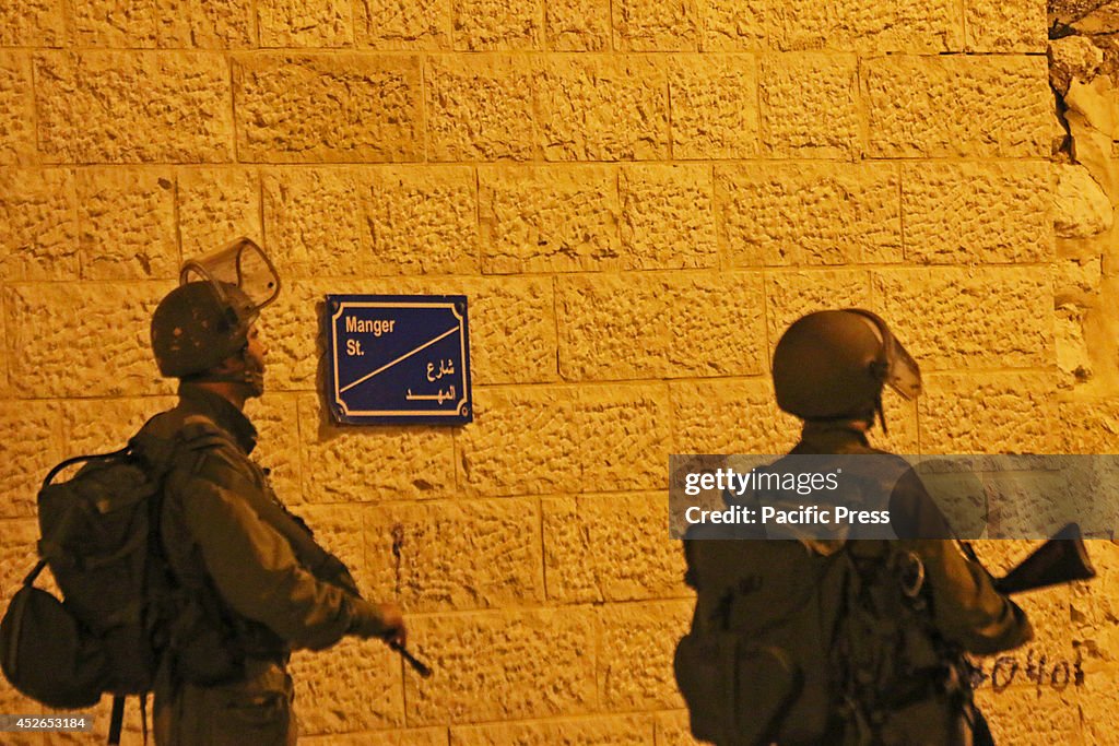 Two Israeli soldiers stand on Manger Street in Bethlehem,...