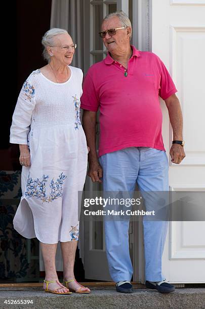 Queen Margrethe II of Denmark and Prince Henrik of Denmark watch the changing of the guard at Grasten Castle on July 25, 2014 in Grasten, Denmark.