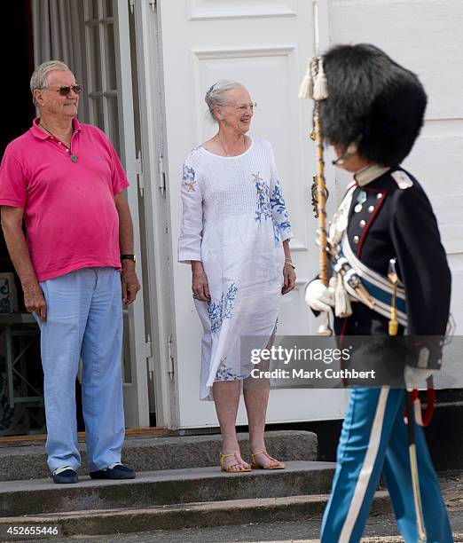 Queen Margrethe II of Denmark and Prince Henrik of Denmark watch the changing of the guard at Grasten Castle on July 25, 2014 in Grasten, Denmark.