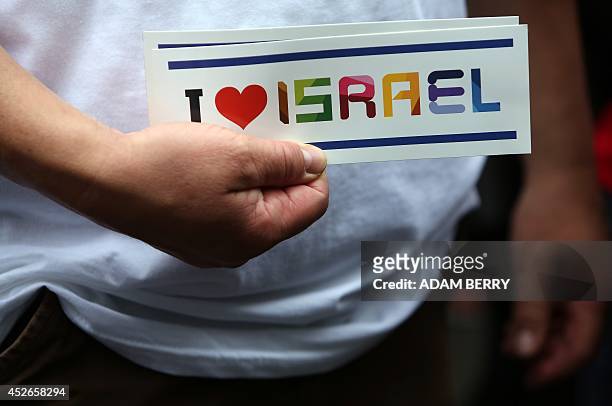 Demonstrator holds cards reading "I love Israel" during a counter demonstration against Al-Quds Day, an event intended to express solidarity with the...