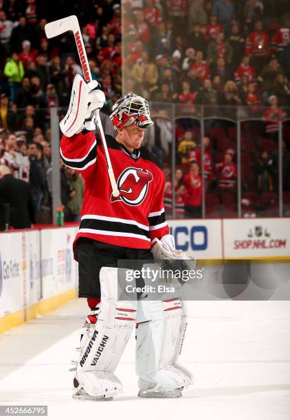 Cory Schneider of the New Jersey Devils salutes the fans after the game against the Buffalo Sabres at Prudential Center on November 30, 2013 in...