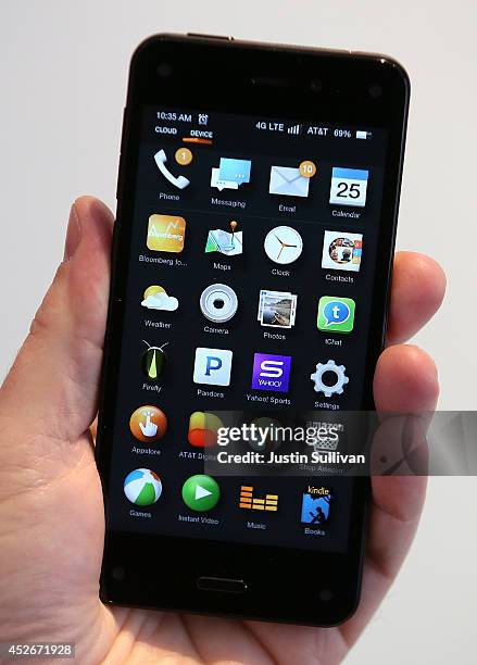 An AT&T worker holds the new Amazon Fire phone at an AT&T store on July 25, 2014 in San Francisco, California. Amazon's Fire phone is going on sale...