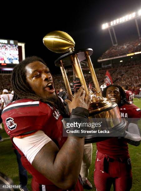 Jadeveon Clowney of the South Carolina Gamecocks and teammate Victor Hampton celebrate after defeating the Clemson Tigers 31-17 after their game at...