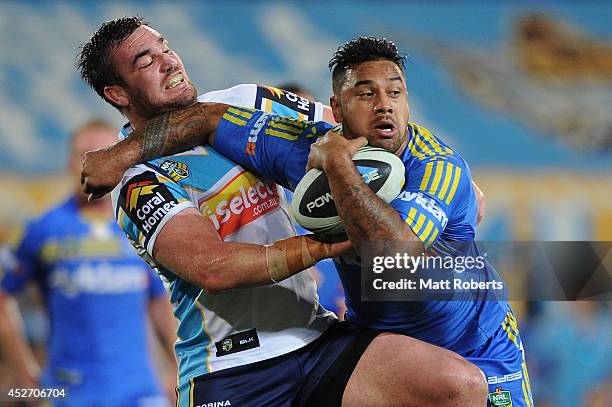 Kenny Edwards of the Eels is tackled by Luke Douglas of the Titans during the round 20 NRL match between the Gold Coast Titans and the Parramatta...