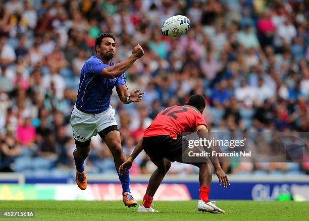 Lio Lolo of Samoa passes the ball as Emmanuel Guise of Paua New guines closes in, in the Rugby Sevens match between Samoa and Papua New Guinea at...